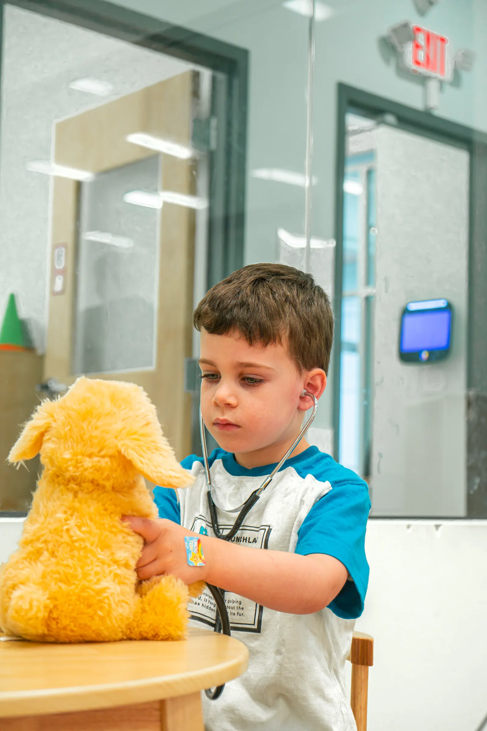 A child holding a plush toy in the classroom