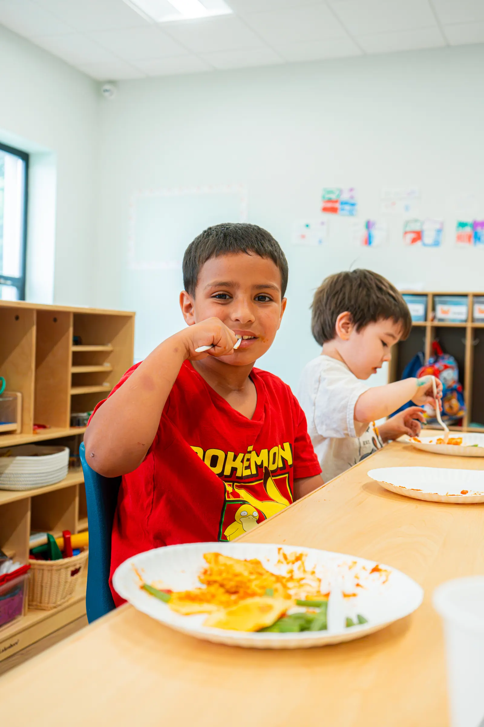 A child enjoying lunch at the classroom table