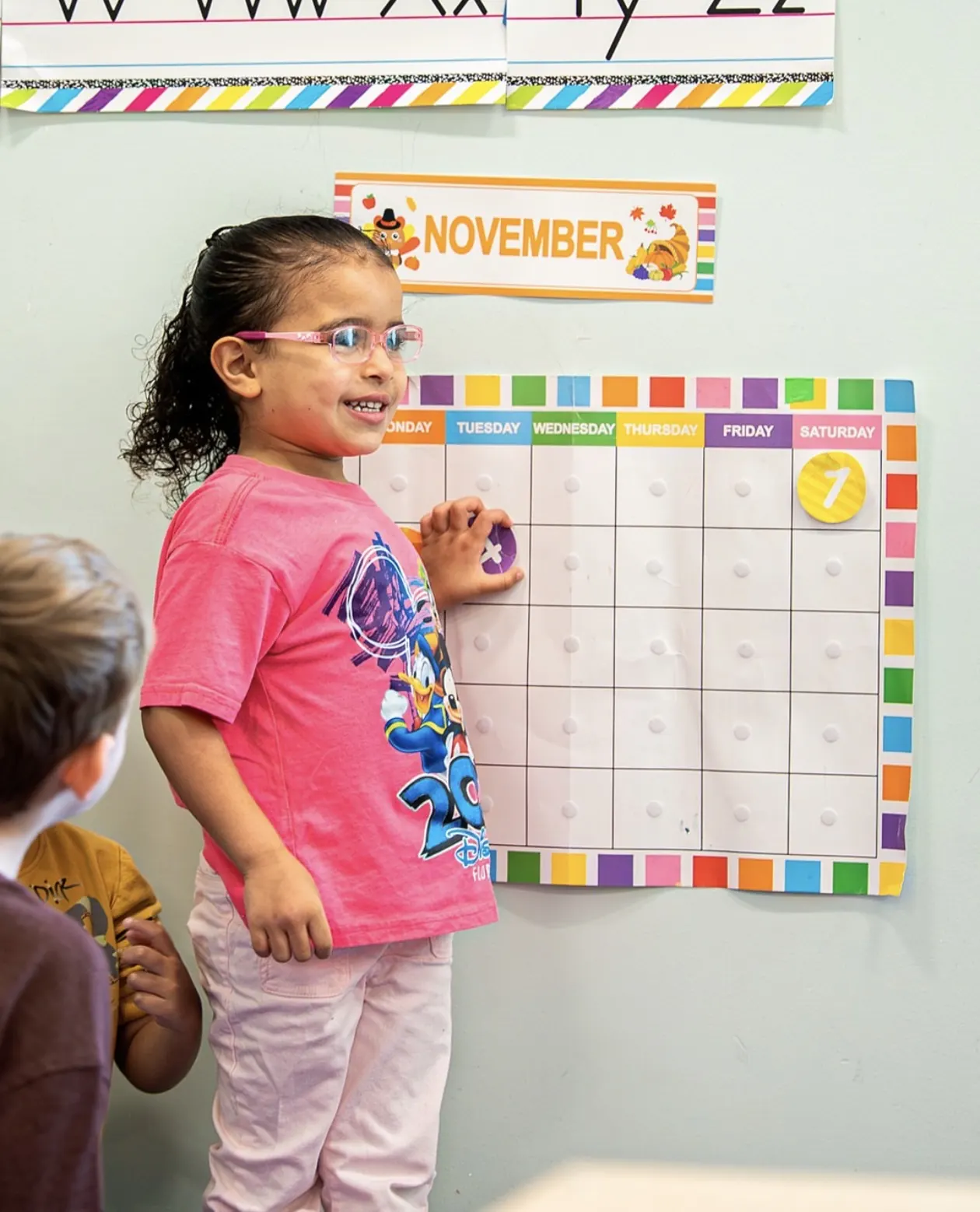 A Pre-K student working on the classroom calendar