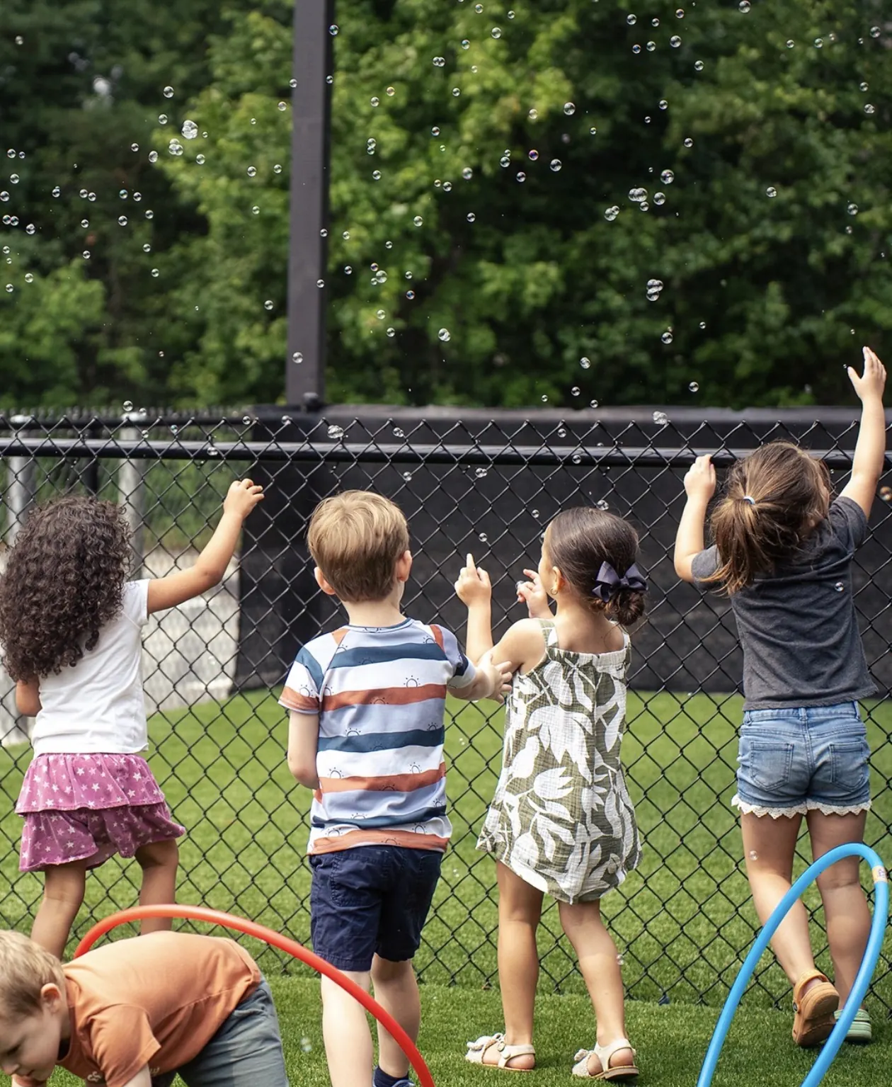 Children chasing bubbles outside