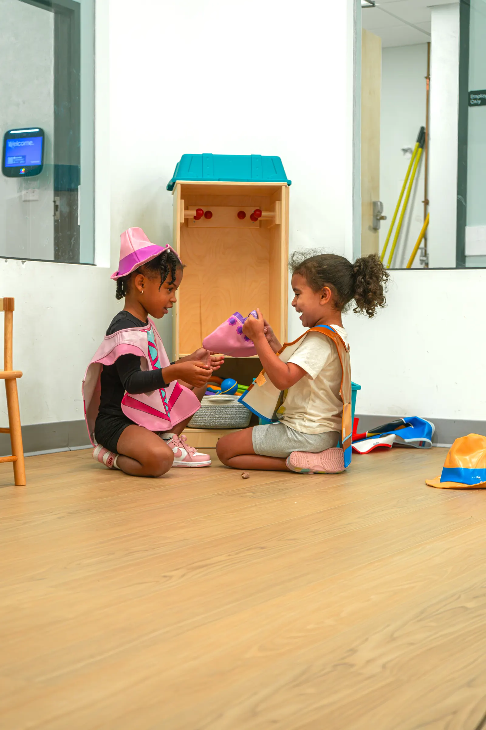 Two toddlers playing together on the classroom floor